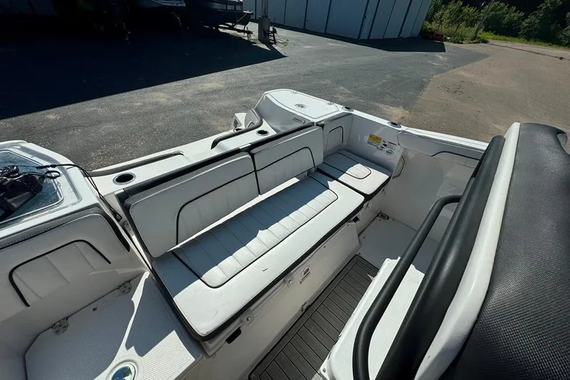 Slide: The Image of 2023 Yamaha Boats 255 FSH Sport E interior with white seating and storage compartments. - 8