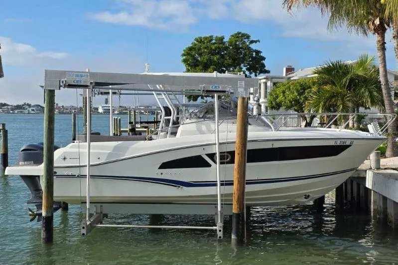 The Image of 2020 Jeanneau Leader 9.0 WA boat on lift by waterfront, palm trees in background. - 0