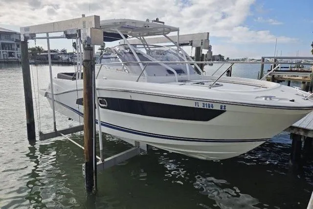 Slide: The Image of 2020 Jeanneau Leader 9.0 WA boat on lift, docked by waterfront homes. - 2