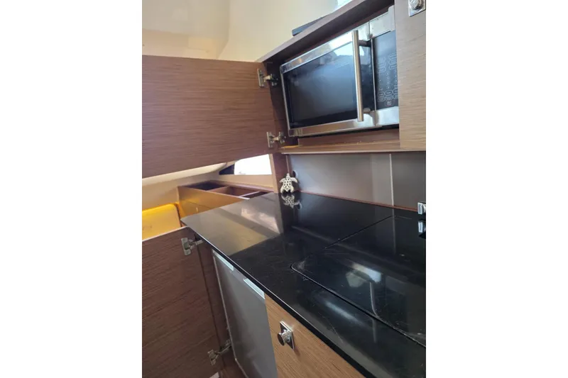 Slide: The Image of 2020 Jeanneau Leader 9.0 WA yacht kitchen with microwave and sleek cabinetry. - 6