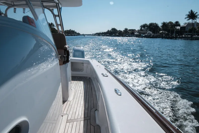 Slide: The Image of 2018 Winter Custom Yachts Center Console cruising on a sunny waterway. - 10