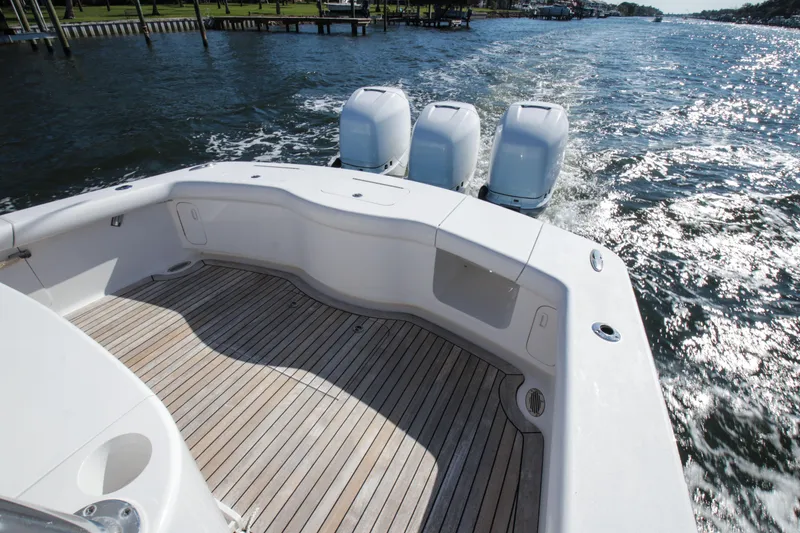 Slide: The Image of 2018 Winter Custom Yachts Center Console with triple engines on open water. - 11