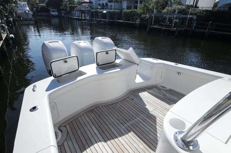 Slide: The Image of 2018 Winter Custom Yachts Center Console boat with open storage compartments, docked by a canal. - 12