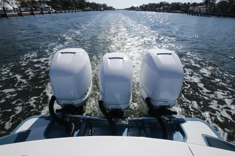 Slide: The Image of 2018 Winter Custom Yachts Center Console with triple outboard engines on open water. - 16