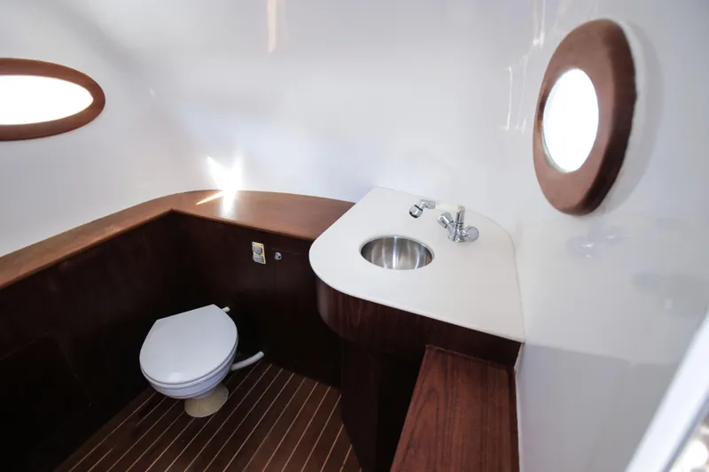 Slide: The Image of Luxurious 2018 Winter Custom Yachts Center Console bathroom with wooden accents and porthole window. - 17