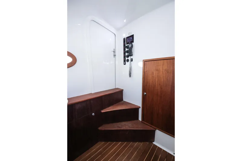 Slide: The Image of Interior of 2018 Winter Custom Yachts Center Console with wooden stairs and control panel. - 19