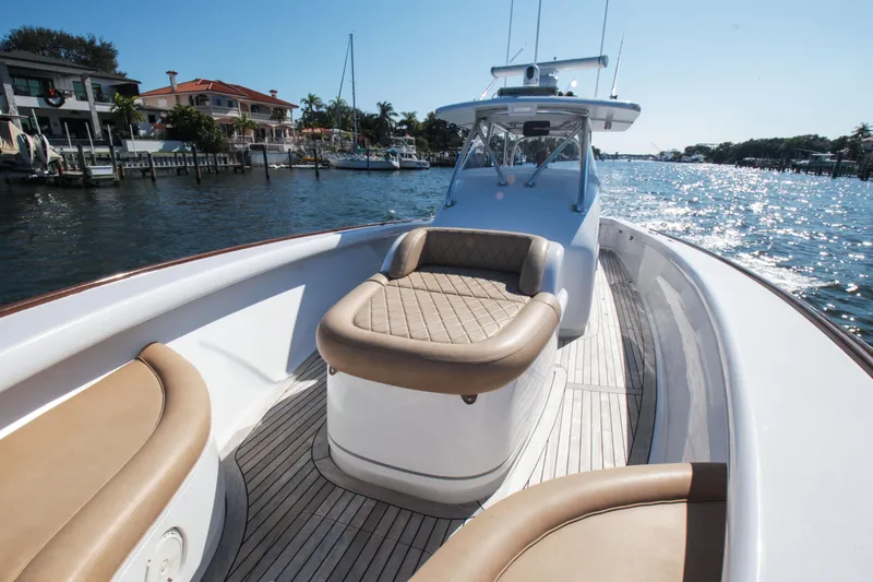 Slide: The Image of 2018 Winter Custom Yachts Center Console on sunny waterfront, featuring luxurious seating. - 6