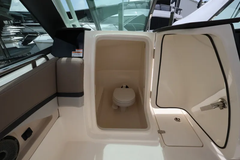 Slide: The Image of The image shows the interior of a Boston Whaler 240 Vantage boat with a small toilet. - 21