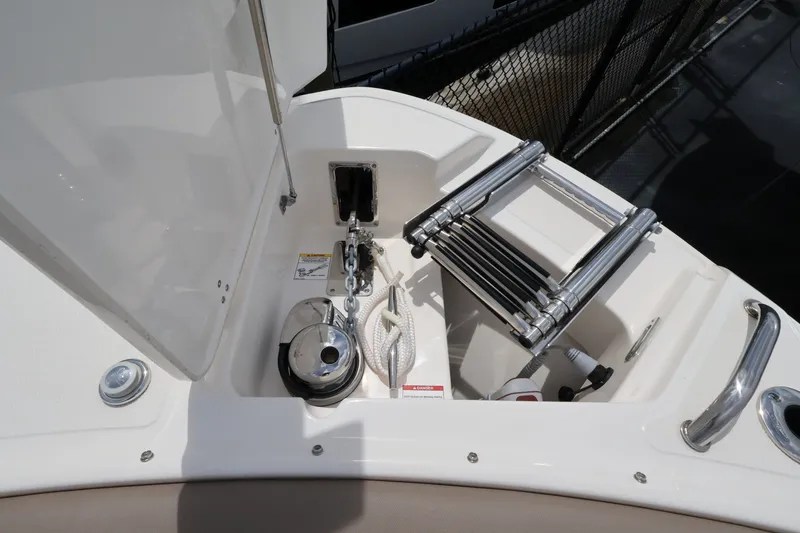 Slide: The Image of The 2026 Boston Whaler 240 Vantage features a storage area with an anchor, rope, and ladder. - 27