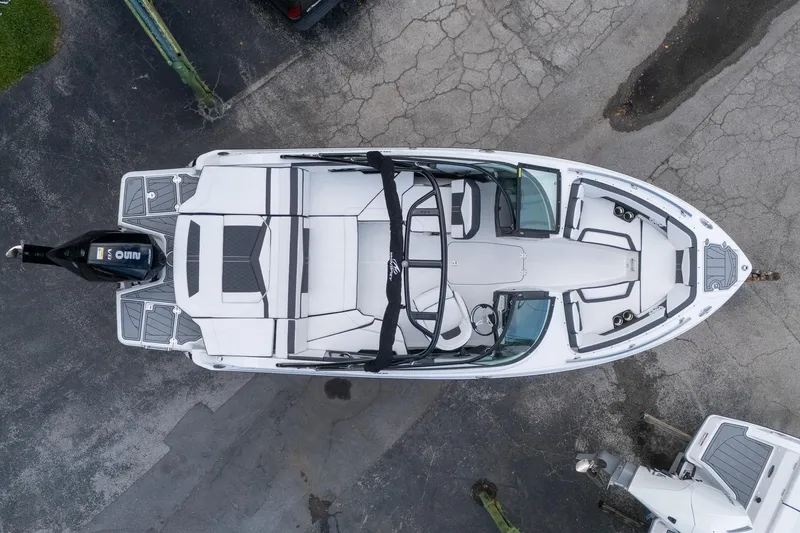 Slide: The Image of 2024 Monterey 235SS Super Sport boat, aerial view, sleek design, parked on pavement. - 2