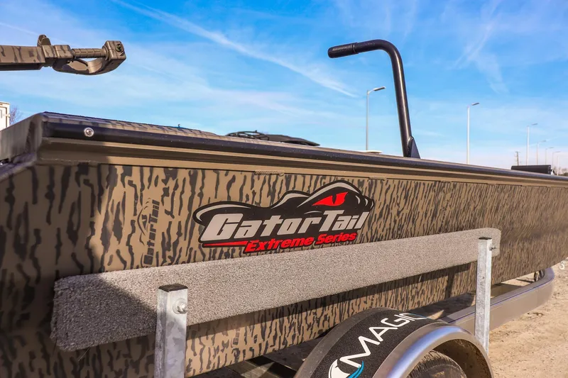 Slide: The Image of 2026 Gator Tail 1860 Extreme Series boat with camouflage design under a clear blue sky. - 13