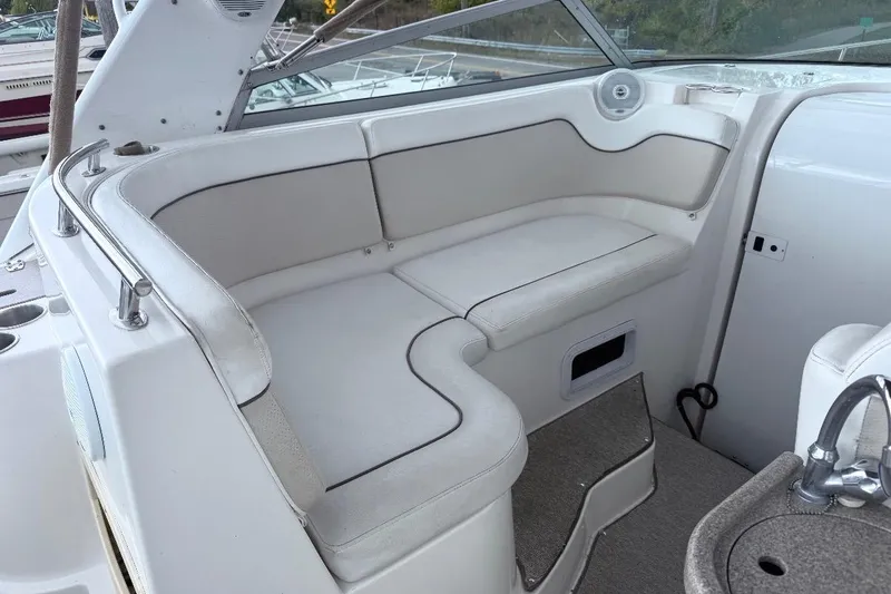 Slide: The Image of 2006 Rinker Fiesta Vee 300 boat interior with white seating and compact sink area. - 4
