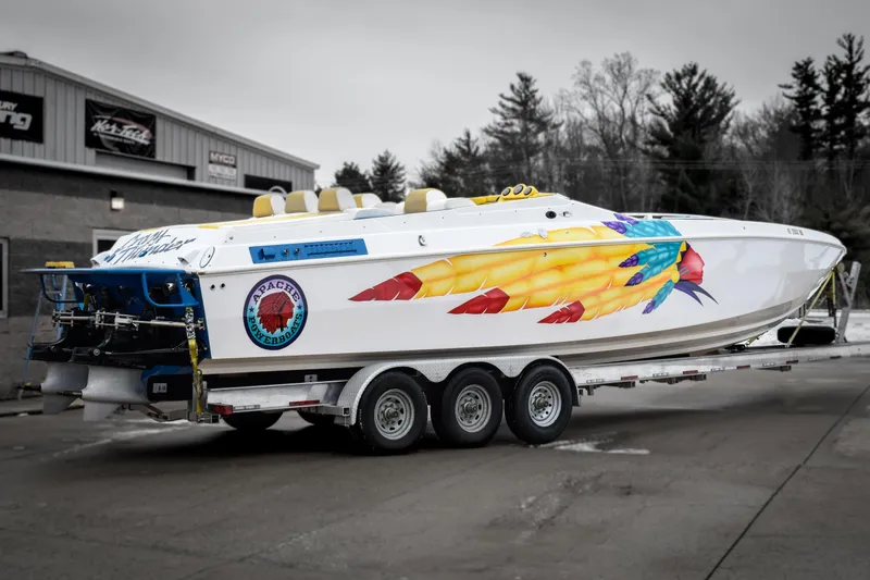Slide: The Image of 1998 Apache 36 WARRIOR powerboat with vibrant graphics on a trailer. - 2