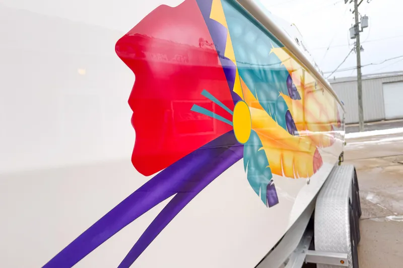 Slide: The Image of Colorful design on 1998 Apache 36 WARRIOR boat, featuring vibrant feathers and abstract shapes. - 7