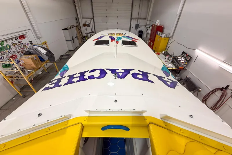 Slide: The Image of 1998 Apache 36 WARRIOR boat in a workshop, showcasing vibrant graphics and sleek design. - 9