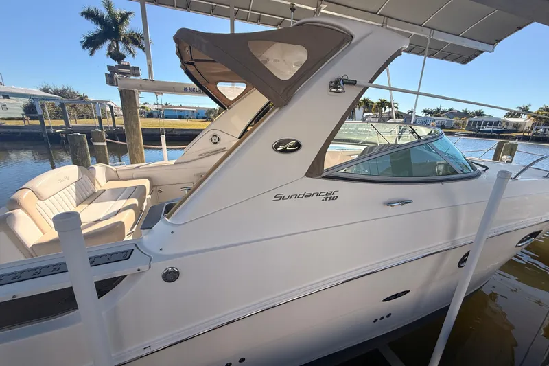 Slide: The Image of 2012 Sea Ray 310 Sundancer boat docked, featuring sleek design and comfortable seating. - 100