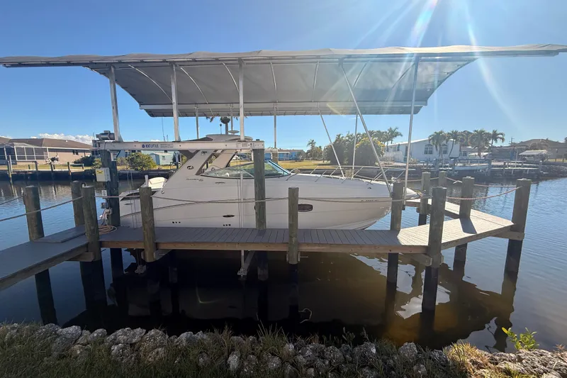 Slide: The Image of 2012 Sea Ray 310 Sundancer docked under a canopy on a sunny day. - 102