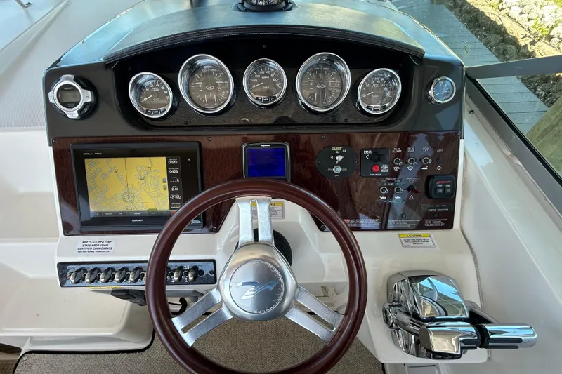 Slide: The Image of 2012 Sea Ray Sundancer 310 yacht docked, showcasing spacious deck and seating area. - 117