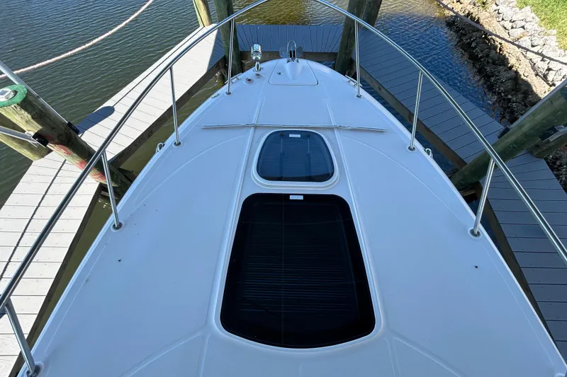 Slide: The Image of Interior of 2012 Sea Ray Sundancer 310, featuring beige seating and wooden accents. - 122