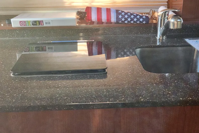 Slide: The Image of 2012 Sea Ray 310 Sundancer docked, rear view with water reflection. - 13