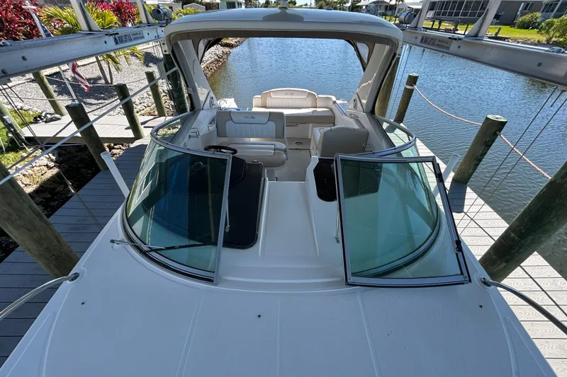 Slide: The Image of Interior cabinet of 2012 Sea Ray Sundancer 310 boat, featuring wood finish and metal hinges. - 130