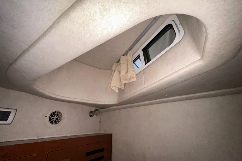 Slide: The Image of Interior seating of 2012 Sea Ray Sundancer 310 with beige upholstery and wooden accents. - 146