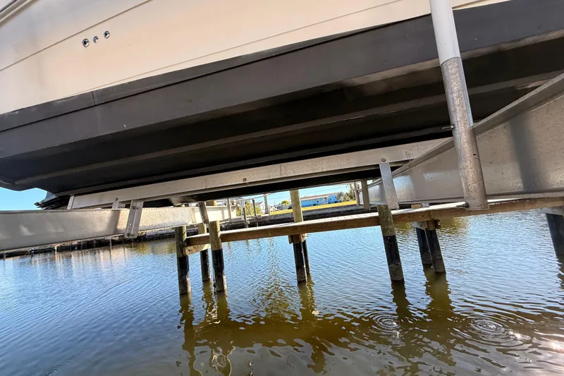 Slide: The Image of 2012 Sea Ray 310 Sundancer on boat lift above calm water. - 16