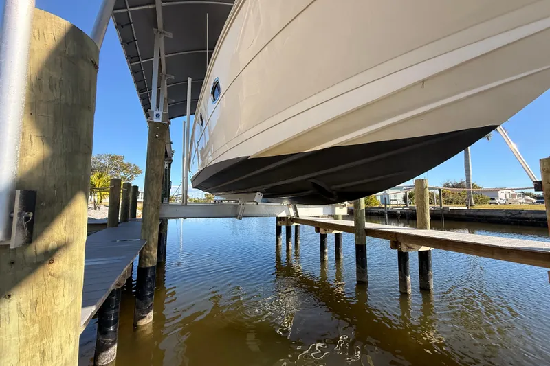 Slide: The Image of 2012 Sea Ray 310 Sundancer boat on lift over water at marina. - 17