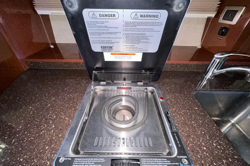 Slide: The Image of Interior storage compartment of 2012 Sea Ray Sundancer 310 boat, featuring wood finish and ventilation slots. - 195