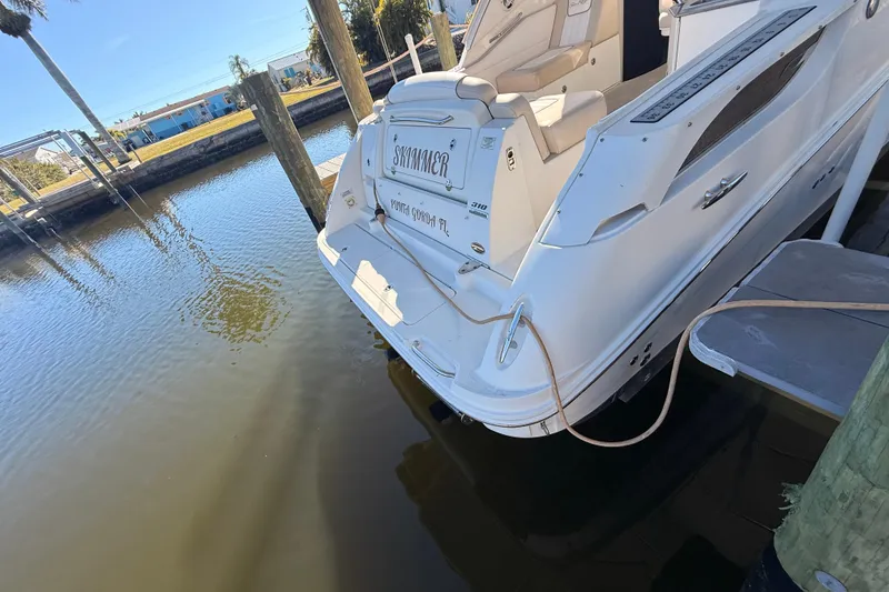 Slide: The Image of 2012 Sea Ray 310 Sundancer docked at a marina, rear view. - 23