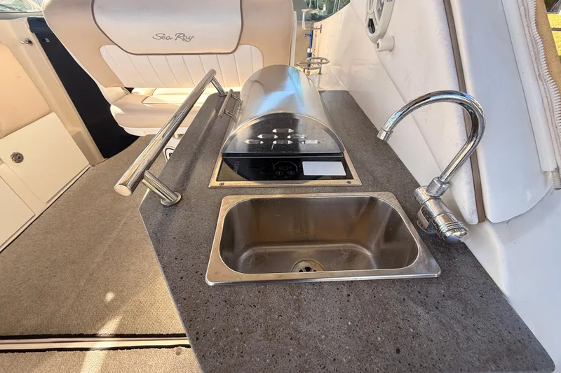 Slide: The Image of 2012 Sea Ray 310 Sundancer boat interior with sink and grill station. - 29