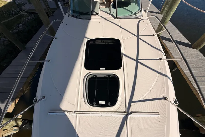 Slide: The Image of 2012 Sea Ray 310 Sundancer boat deck with hatches, docked at marina. - 46