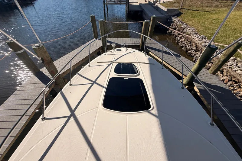 Slide: The Image of 2012 Sea Ray 310 Sundancer docked, view from bow, sunny day reflections on water. - 47
