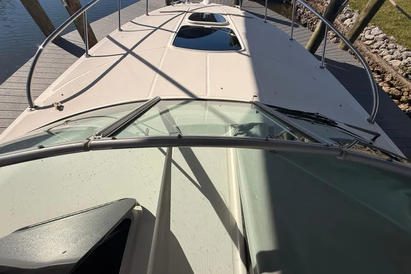 Slide: The Image of 2012 Sea Ray 310 Sundancer boat docked, view from the bow with railings and deck. - 51