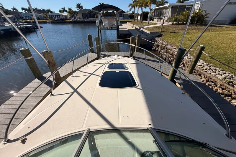 Slide: The Image of 2012 Sea Ray 310 Sundancer docked at a marina with palm trees in the background. - 53
