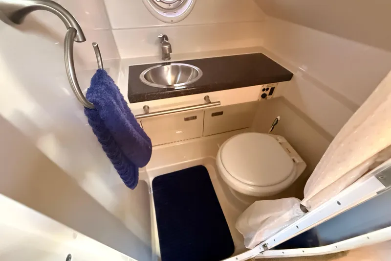 Slide: The Image of Compact bathroom in 2012 Sea Ray 310 Sundancer yacht with sink, toilet, and towel. - 59