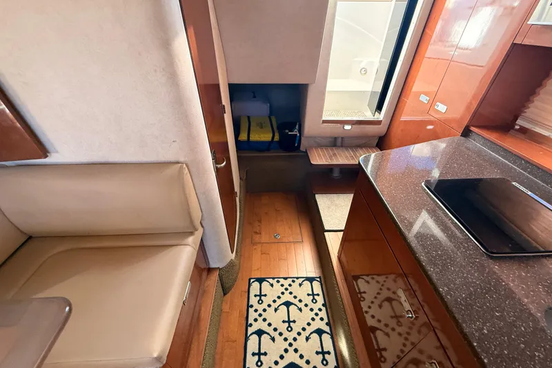 Slide: The Image of Interior of 2012 Sea Ray 310 Sundancer with seating, kitchenette, and wooden flooring. - 65