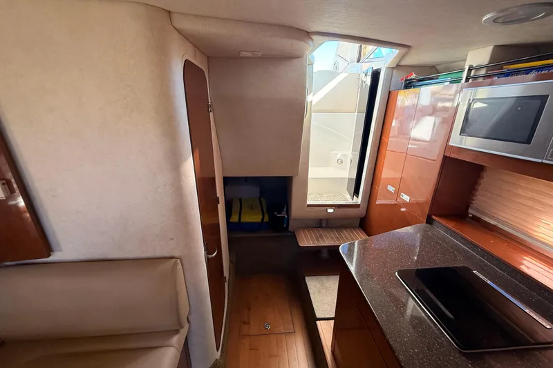 Slide: The Image of Interior of 2012 Sea Ray 310 Sundancer yacht with kitchenette and seating area. - 66