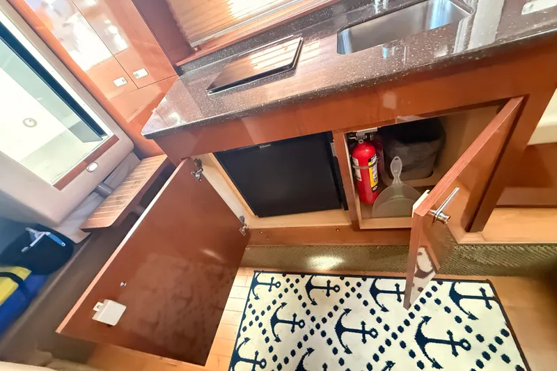 Slide: The Image of Interior of 2012 Sea Ray 310 Sundancer showing kitchen area with cabinets and sink. - 67