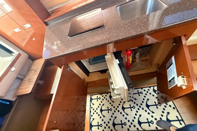 Slide: The Image of Interior of 2012 Sea Ray 310 Sundancer showing kitchenette with sink, fridge, and storage. - 71