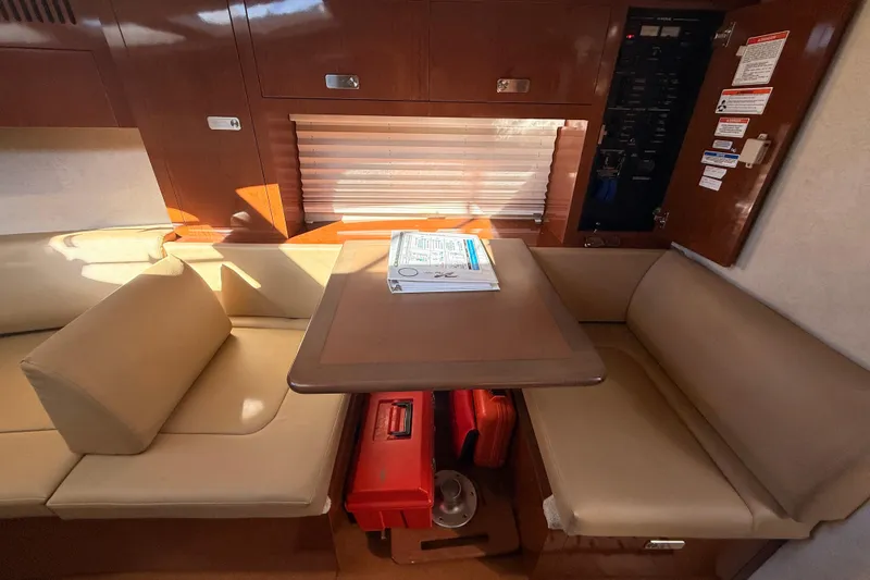Slide: The Image of Interior of 2012 Sea Ray 310 Sundancer with beige seating and wooden table. - 74