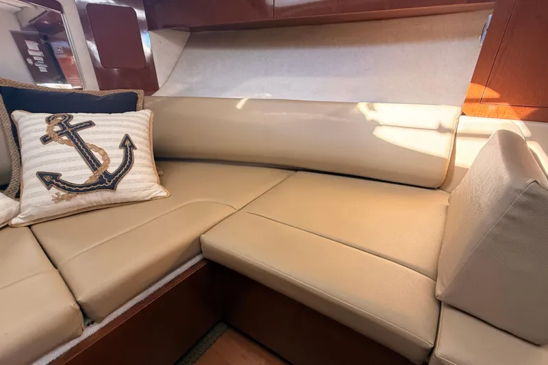 Slide: The Image of Luxurious interior seating of 2012 Sea Ray 310 Sundancer with nautical-themed pillow. - 77