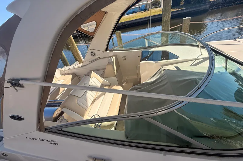 Slide: The Image of 2012 Sea Ray 310 Sundancer boat interior with beige seating and clear canopy. - 87