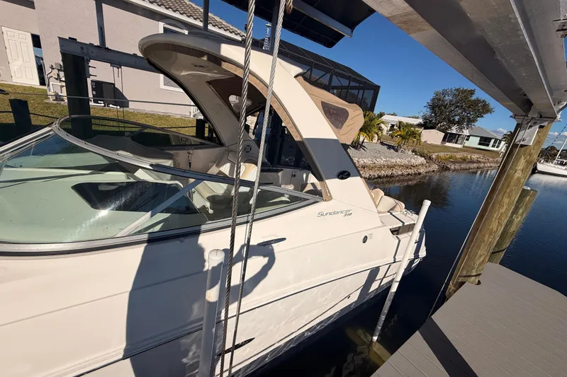 Slide: The Image of 2012 Sea Ray 310 Sundancer docked by a waterfront home. - 91