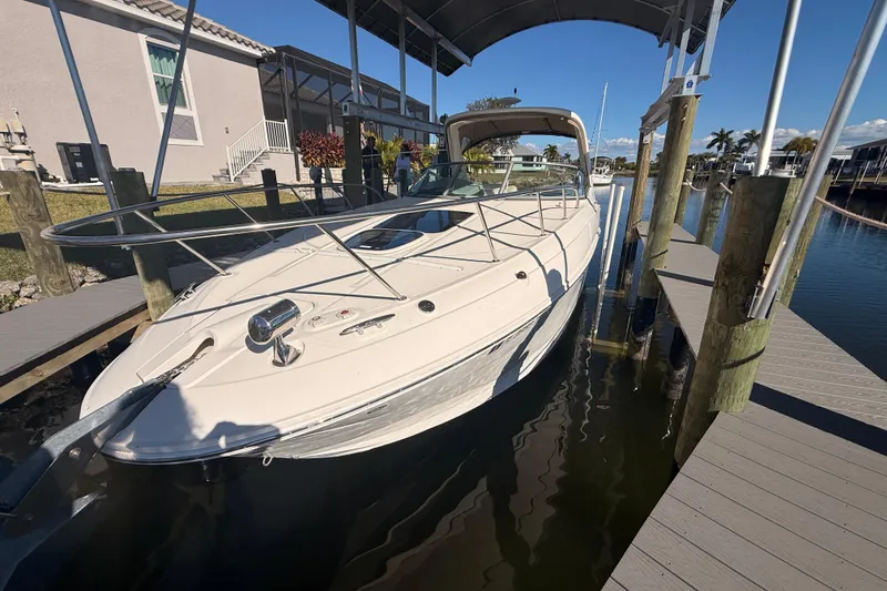 Slide: The Image of 2012 Sea Ray 310 Sundancer docked at a marina under a canopy. - 93