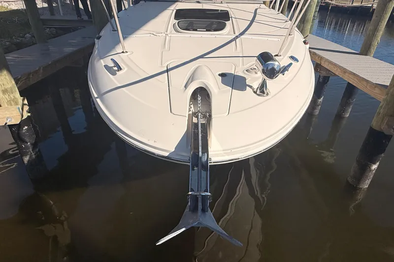 Slide: The Image of 2012 Sea Ray 310 Sundancer boat docked, showing bow and anchor in marina. - 94