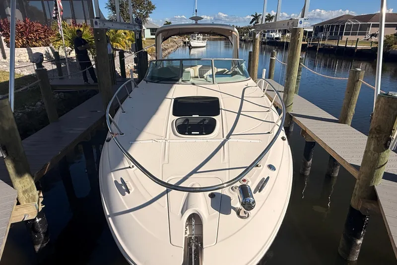 Slide: The Image of 2012 Sea Ray 310 Sundancer docked in a sunny marina setting. - 95