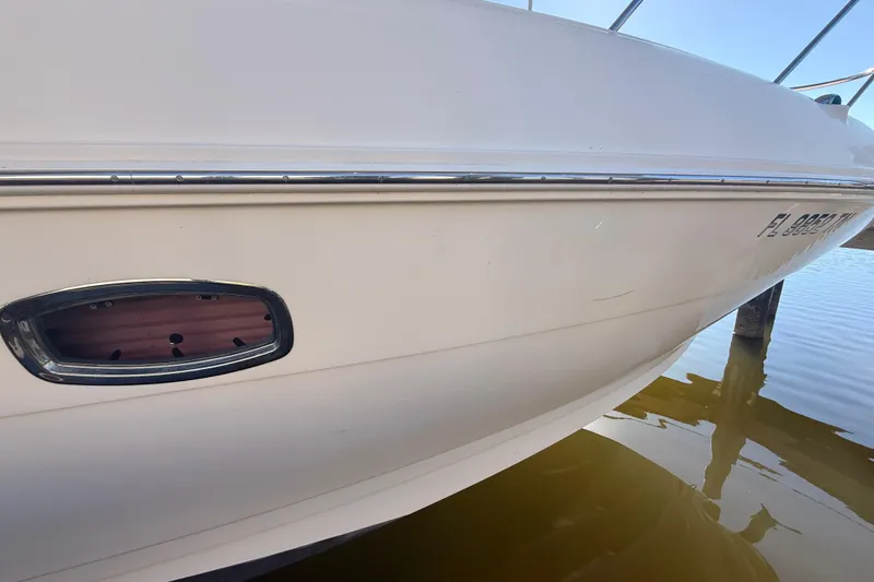 Slide: The Image of 2012 Sea Ray 310 Sundancer boat hull close-up on water. - 98