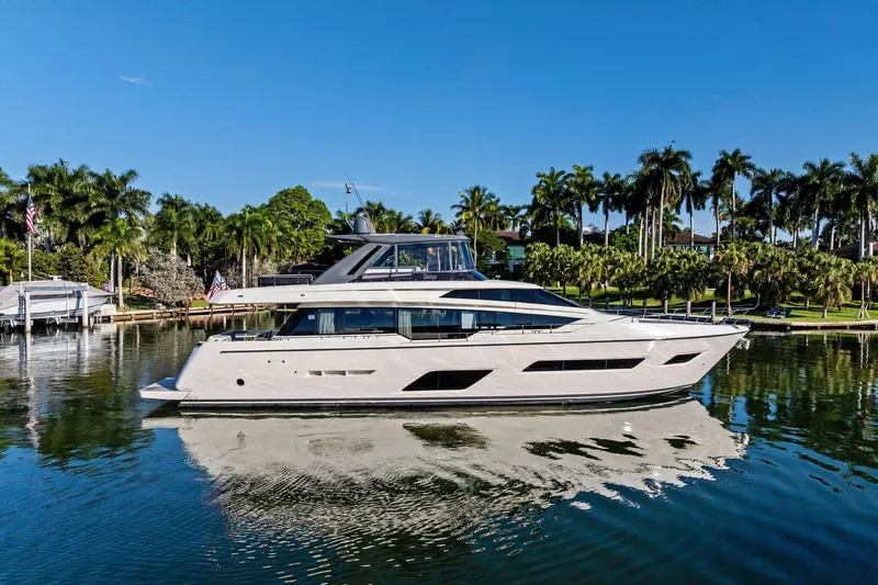 The Image of Luxurious 2019 Ferretti Yachts 780 cruising on a serene waterway, surrounded by lush greenery. - 0