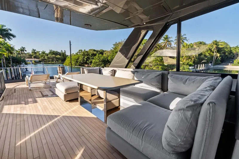 Slide: The Image of Luxurious 2019 Ferretti Yachts 780 deck with plush seating and scenic waterfront view. - 19